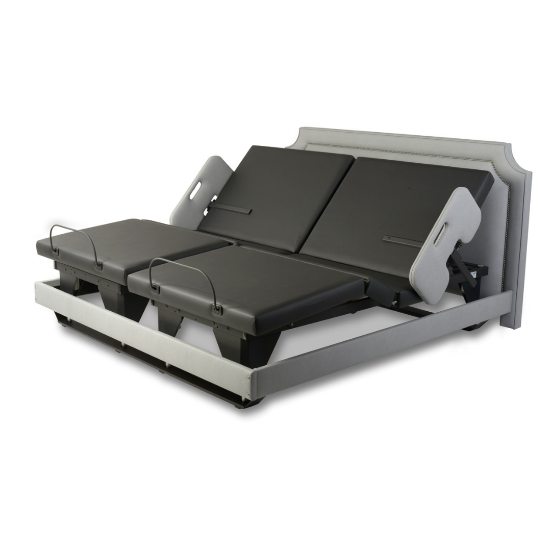 The Assured Comfort® Signature Series Hi-Low Adjustable Bed is a split-king with two black cushioned sections, separate headrests, and a light gray fabric frame, offering customizable comfort and support for two people.